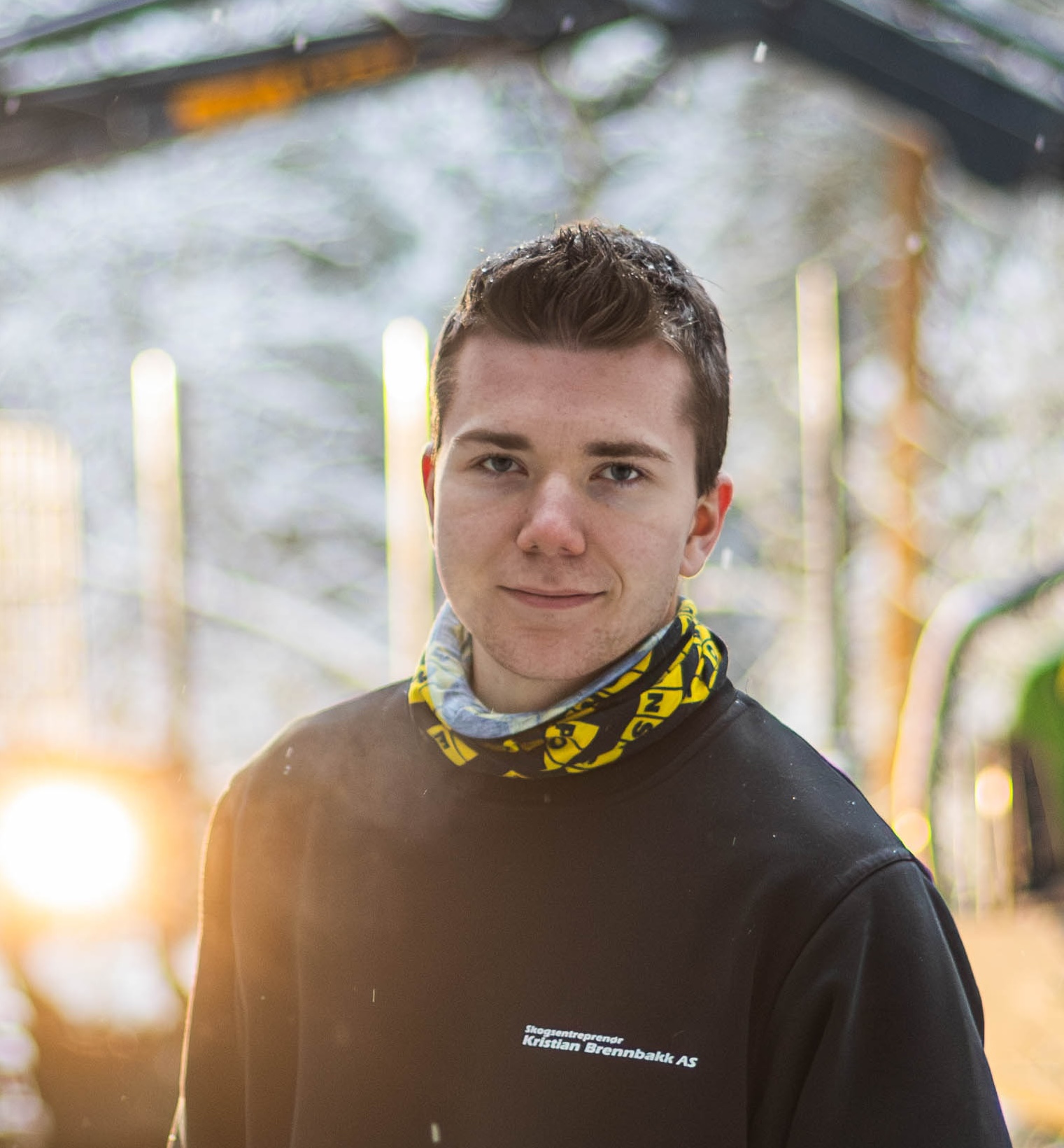 gutt i skog står foran skogsmaskin